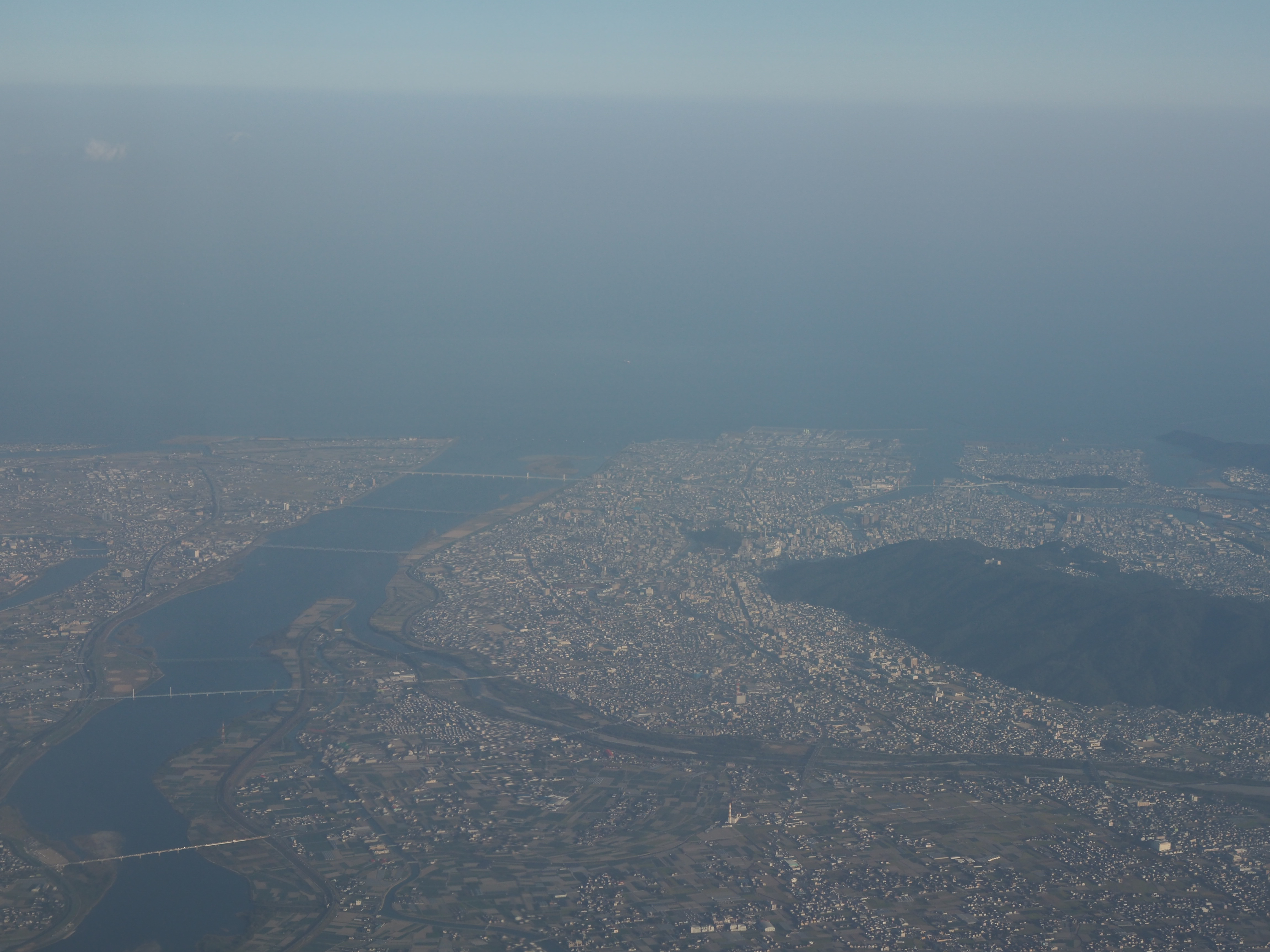 从客机舷窗处俯瞰到的大阪市区（因为舷窗玻璃刮痕较多且存在大块的模糊区域，所以拍出来的照片会给人一种雾蒙蒙的感觉，其实大阪的天空非常干净）